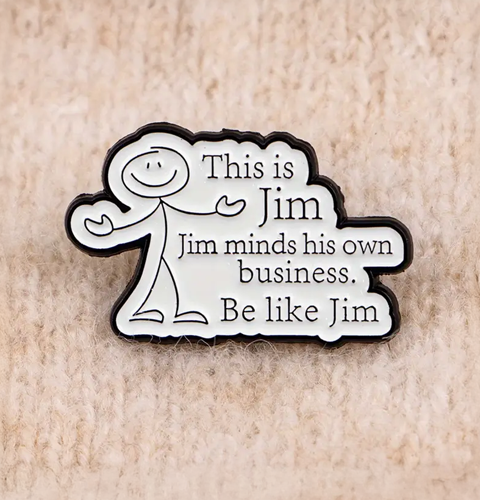 Enamel pin with 'This is Jim, Jim minds his own business. Be like Jim' text on a beige background