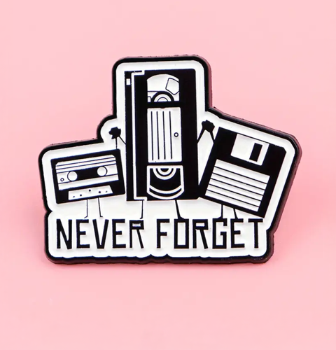Sticker with cassette tape, floppy disk, and VHS tape on a pink background with 'NEVER FORGET' text.