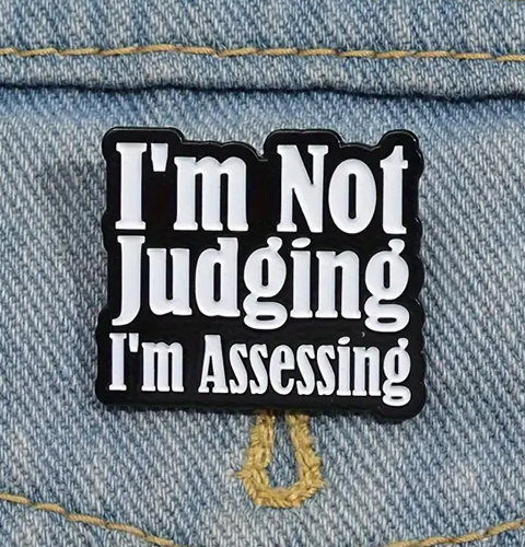 Pin with 'I'm Not Judging, I'm Assessing' text on a denim background